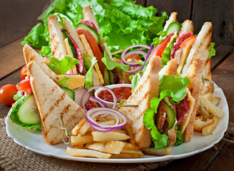 Club sandwich with cheese, cucumber, tomato, smoked meat and sal