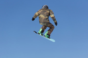 Snowboarder jumps in Snow Park