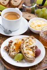 bread with butter, honey, nuts and grapes for breakfast