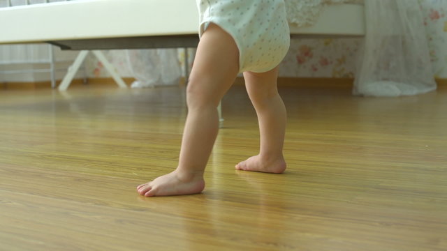 one year a small baby walks funny,dolly shot,close up
