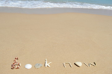 Text 'book now' in the sand