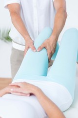 Obraz na płótnie Canvas Physiotherapist doing leg massage to his patient
