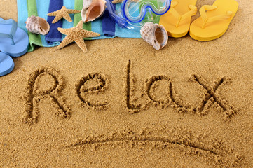 Fototapeta na wymiar Relax word text message written in sand on a tropical beach with seashells and accessories summer holiday vacation relaxation photo