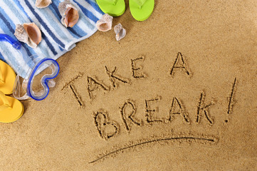 Take a break word message writing written in sand on a tropical beach with seashells and...