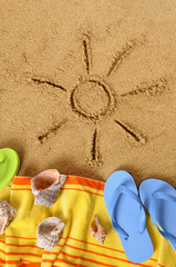 Sun sunbeam drawing drawn in sand on a tropical beach with seashells and accessories summer holiday...