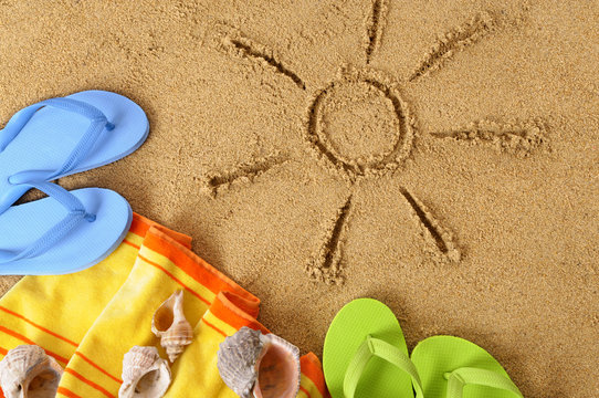 Sun sunbeam drawing drawn in sand on a tropical beach with seashells and accessories summer holiday vacation photo