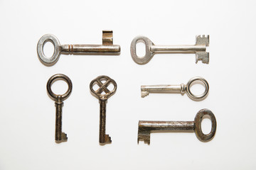 Six old keys to the safe on a white background