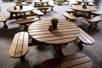 Tavolini rotondi e sedute in doghe  di legno da esterno