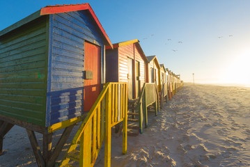 Sunrise at the famous colorful beach huts at Muizenberg Beach
