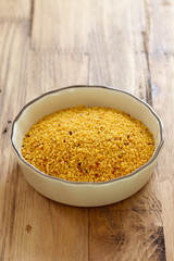 couscous in dish on brown background