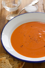 tomato soup in white plate and glass of water