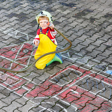 Funny little child of four years having fun with fire truck pict