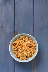 granola in blue bowl on blue background