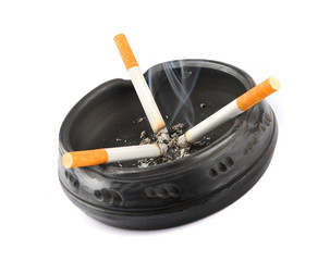 Three lit cigarettes in a black ashtray
