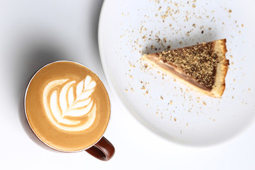 Cup of cappuccino and a piece of cake. Latte art