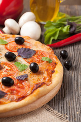 Traditional italian pizza margherita with tomatoes, olives and b