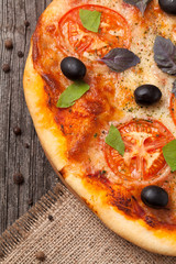 Italian pizza margherita with tomatoes, olives and basil close u