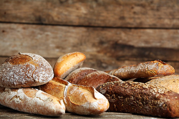 Different fresh bread on old wooden table