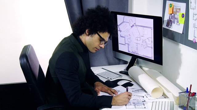 Cool handsome architect working on project in office