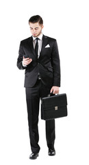 Elegant man in suit with mobile phone and briefcase isolated on white