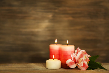 Beautiful composition with candles and spa stones on wooden background
