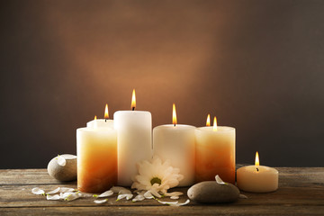 Fototapeta na wymiar Candles with chrysanthemum on wooden background