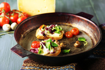 Tasty sandwiches on old pan, on wooden table
