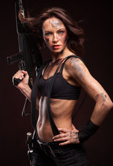 Beautiful young woman holding an automatic assault rifle. 