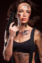 Fototapeta premium Sexy girl in a black dress holding a gun. Riot girl.