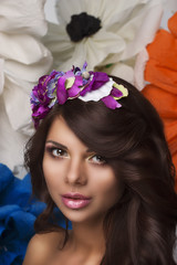 Naklejka premium Beautiful girl model winks with a hoop of flowers in the hair