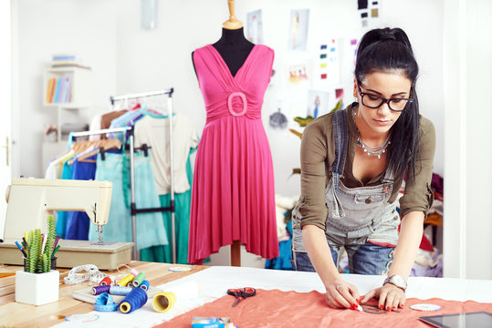 Young female designer drawing on the material