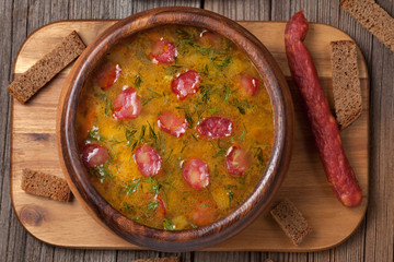 Beer soup with sausage croutons and beer on vintage wooden backg