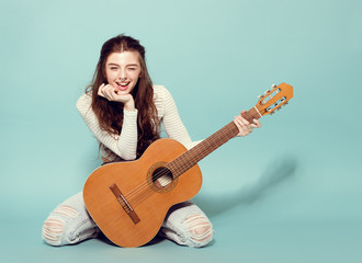 smiling beautiful young girl posing with guitar