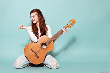 smiling beautiful young girl posing with guitar - 82055407