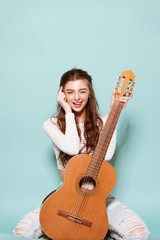 smiling beautiful young girl posing with guitar - 82055621