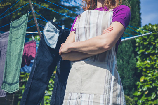 Woman in apron standing by clothes line