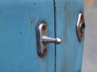 Old latch on a blue car.