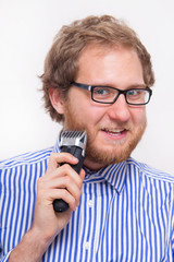 Bearded man with an electric razor