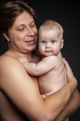 Portrait of happy man holding cute baby boy and looking at him.