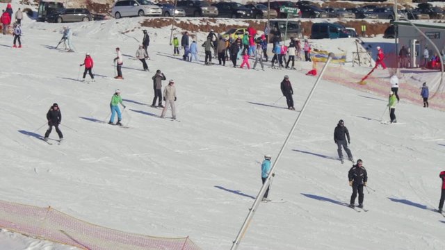 People ride on a ski slope, the view from a distance