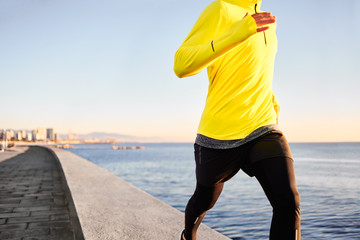 Jogging athlete man running at sun sunset beach in Barcelona cit