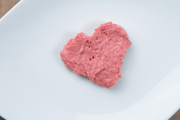 Closeup of a plate with heart-shaped strawberry jam