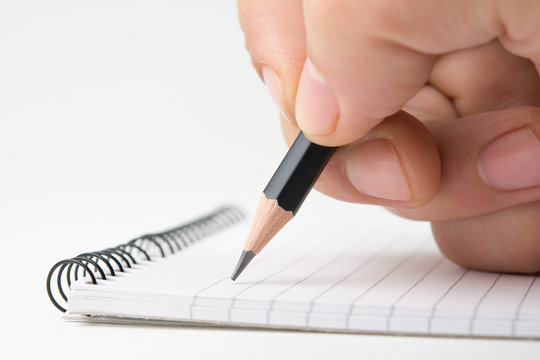 Writing on notepad. Close up, isolated on white