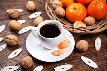 Cup of coffee with tangerines and walnut