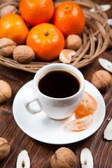 Cup of coffee with tangerines and walnut