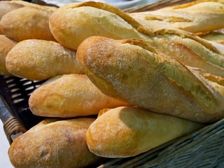 Freshly baked baguette in weaved bread basket.