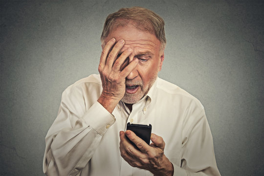 stressed man holding cellphone shocked with message received