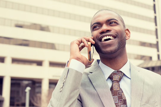 handsome happy laughing businessman talking on mobile phone