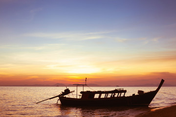 beautiful sunset on the beach with silhouette of boat