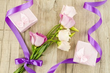 Pink flower and gift box on wooden background
